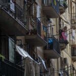Una mujer fuma en el balcón de su vivienda, ubicada en un popular barrio de Barcelona