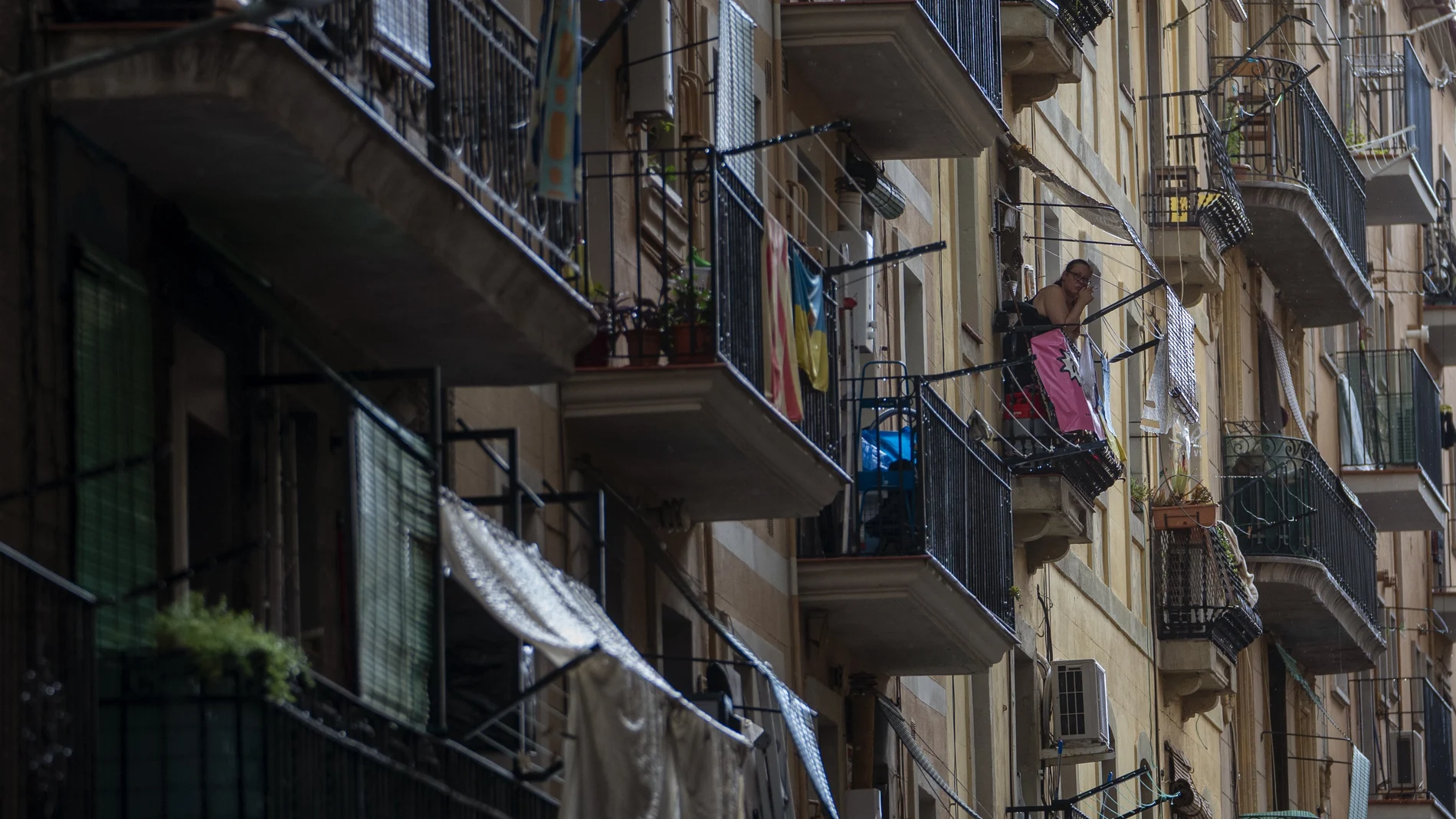 Una mujer fuma en el balcón de su vivienda, ubicada en un popular barrio de Barcelona