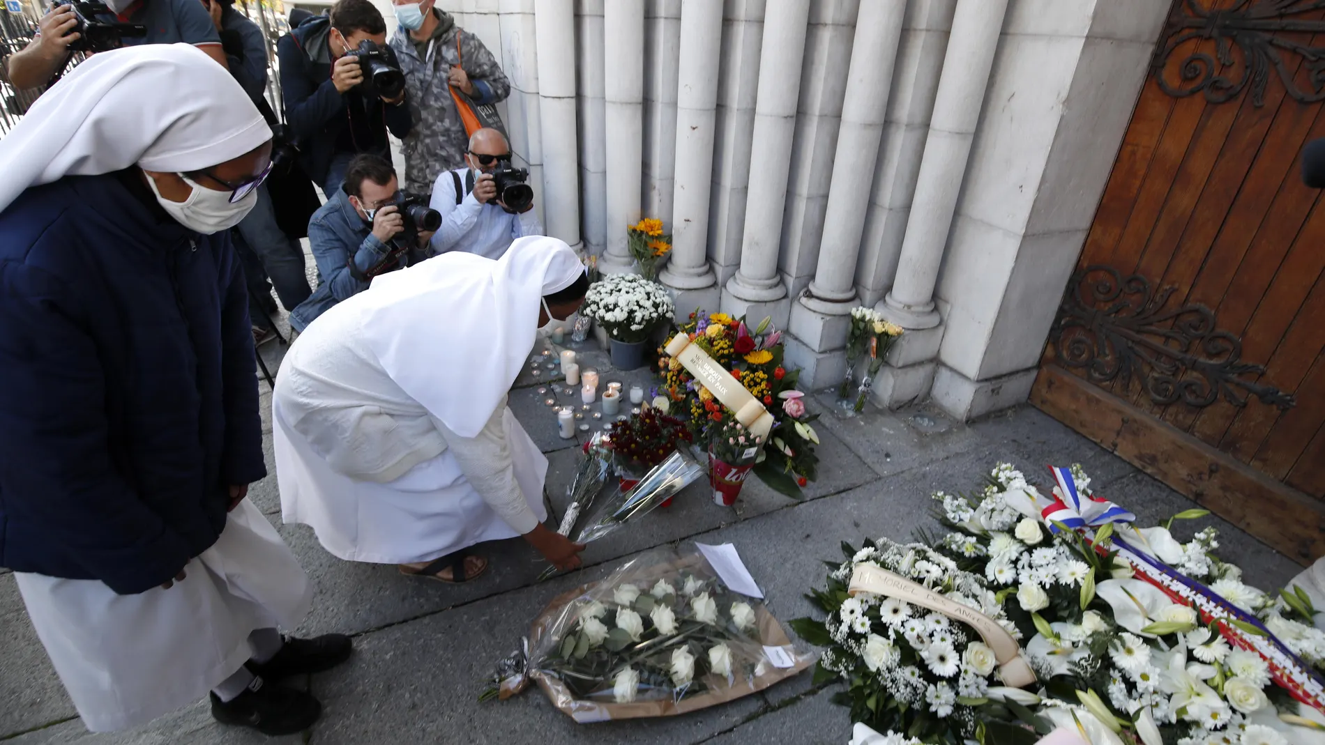 Nice (France), 30/10/2020.- Nuns lay flowers on a makeshift memorial to the victims of the knife attack at the entrance of the Notre Dame Basilica church in Nice, France, 30 October 2020. Three people have died in a terror attack. The attack comes less than a month after the beheading of a French middle school teacher in Paris on 16 October. (Atentado, Francia, Niza) EFE/EPA/SEBASTIEN NOGIER
