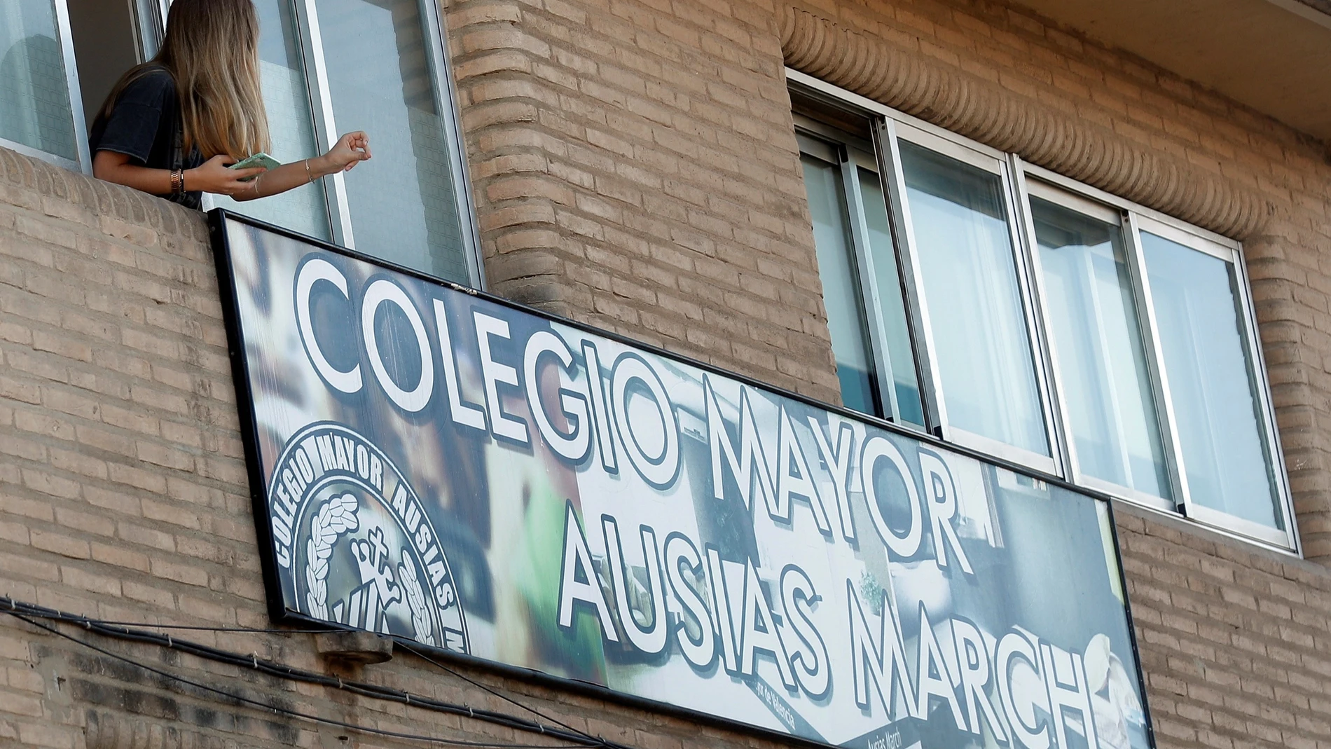 Una joven se asoma por la ventana de la residencia universitaria “Ausias March” de Valencia