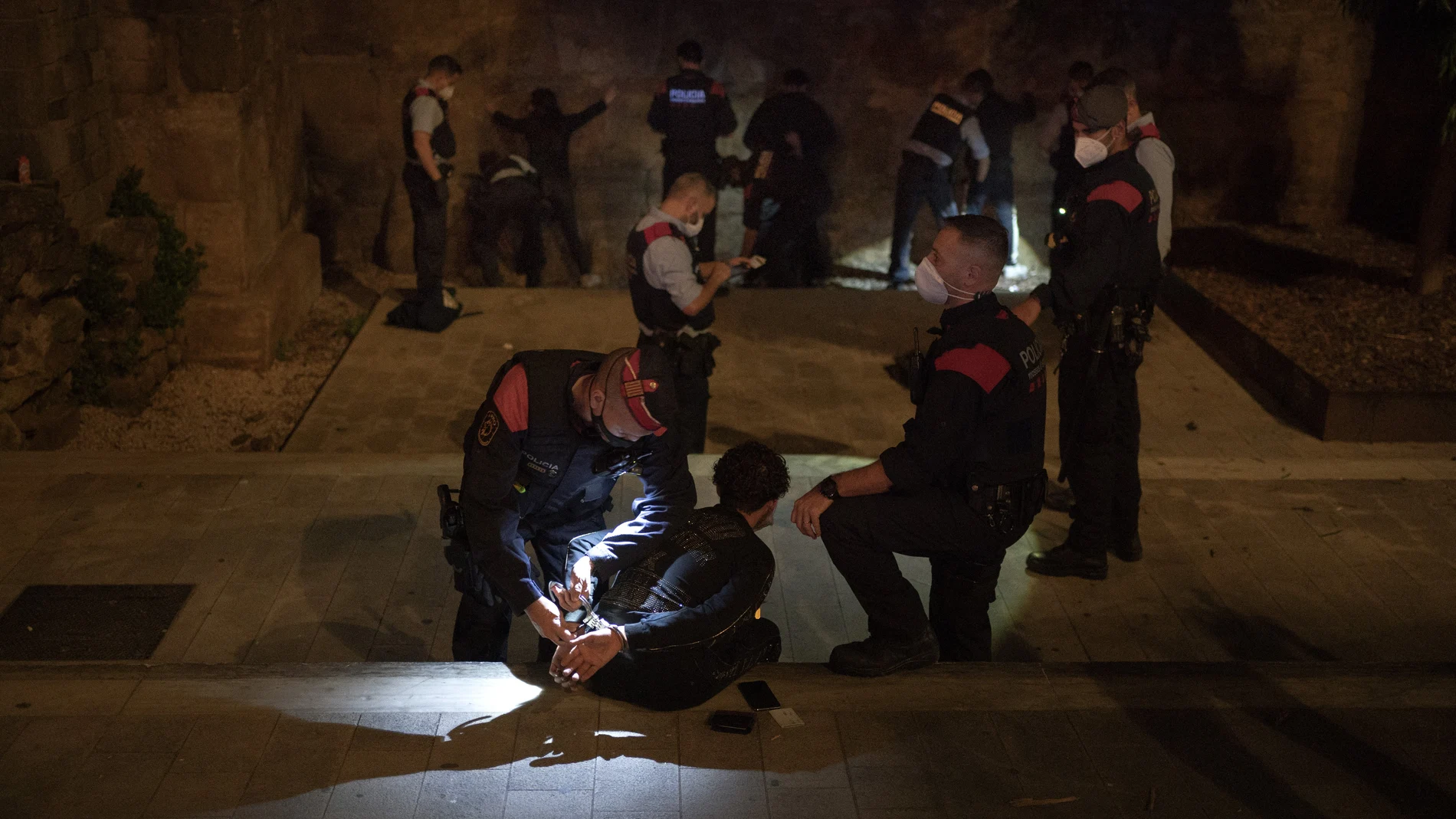 Los Mossos han practicado detenciones en el inicio del toque de queda. (AP Photo/Emilio Morenatti)