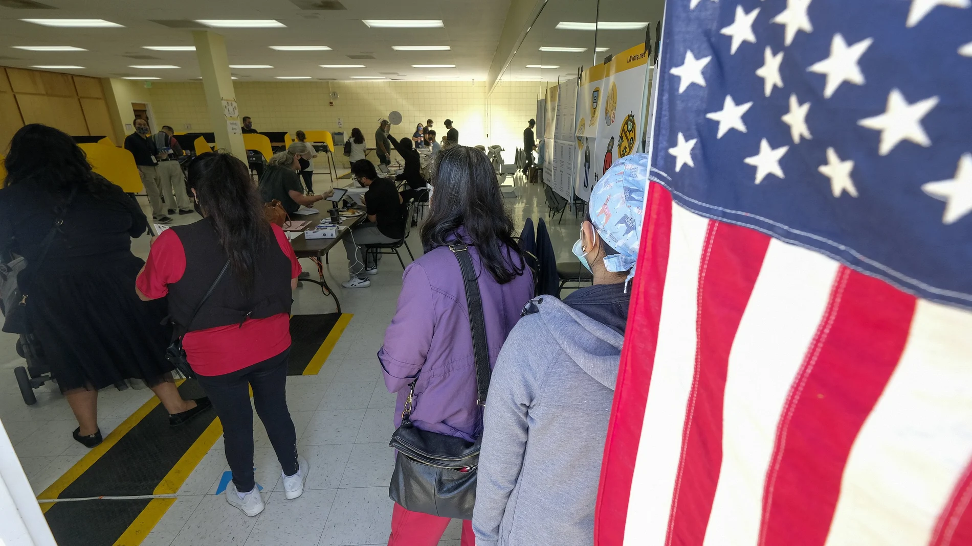 Un grupo de votantes espera su turno para depositar su papeleta en California