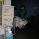 Personal sanitario visita a un paciente ingresado en la Unidad de Cuidados Intensivos –UCI- del Hospital de la Santa Creu i Sant Pau