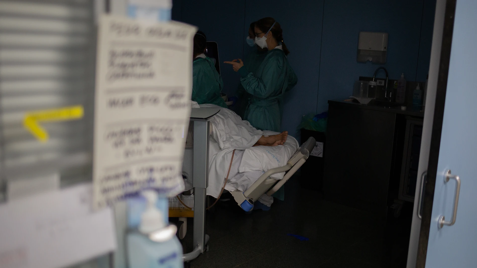 Personal sanitario visita a un paciente ingresado en la Unidad de Cuidados Intensivos –UCI- del Hospital de la Santa Creu i Sant Pau