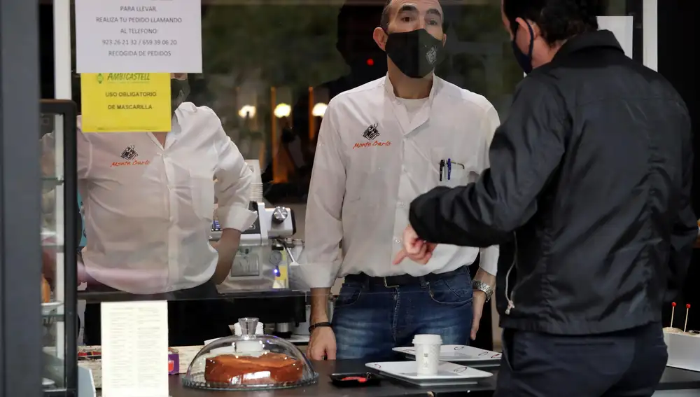 SALAMANCA, 06/11/2020.- Un hombre pide un desayuno para llevar en un establecimiento hostelero este viernes en Salamanca, que despierta con el cierre de la hostelería y los centros comerciales, según lo acordado por el Gobierno autonómico. Podrán abrir los restaurantes y otros alojamientos turísticos, aunque solo para sus clientes o entrega a domicilio o recogida. EFE/J.M.GARCÍA