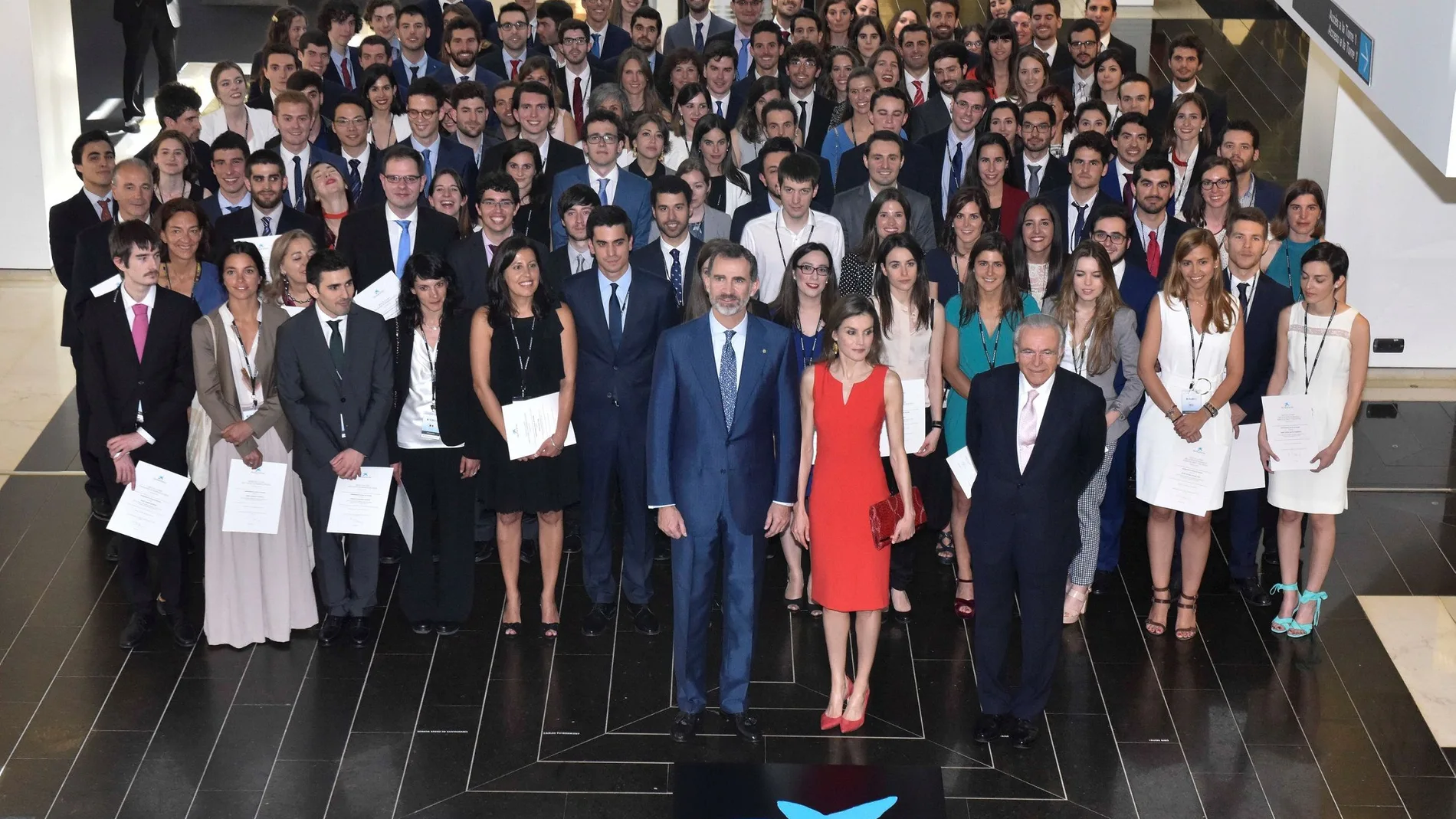 El Rey Felipe VI y la Reina Letizia, acompañados por Isidro Fainé, en una foto de familia junto a algunos de los becados