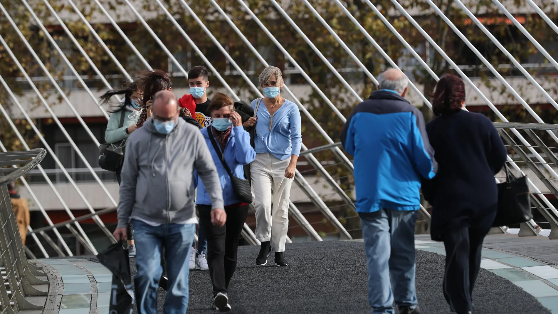 Viandantes se protegen del viento en la capital vizcaína