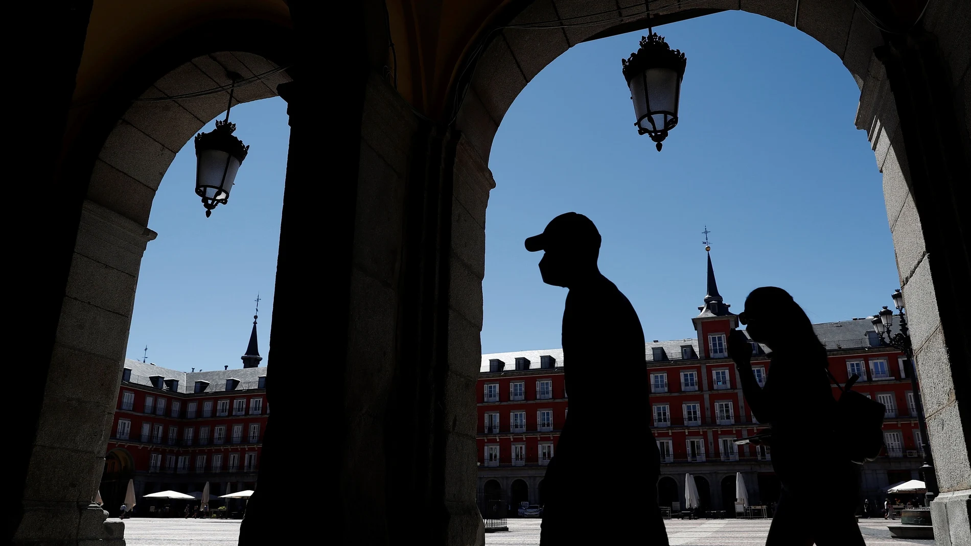 Dos turistas visitan la Plaza Mayor de Madrid.