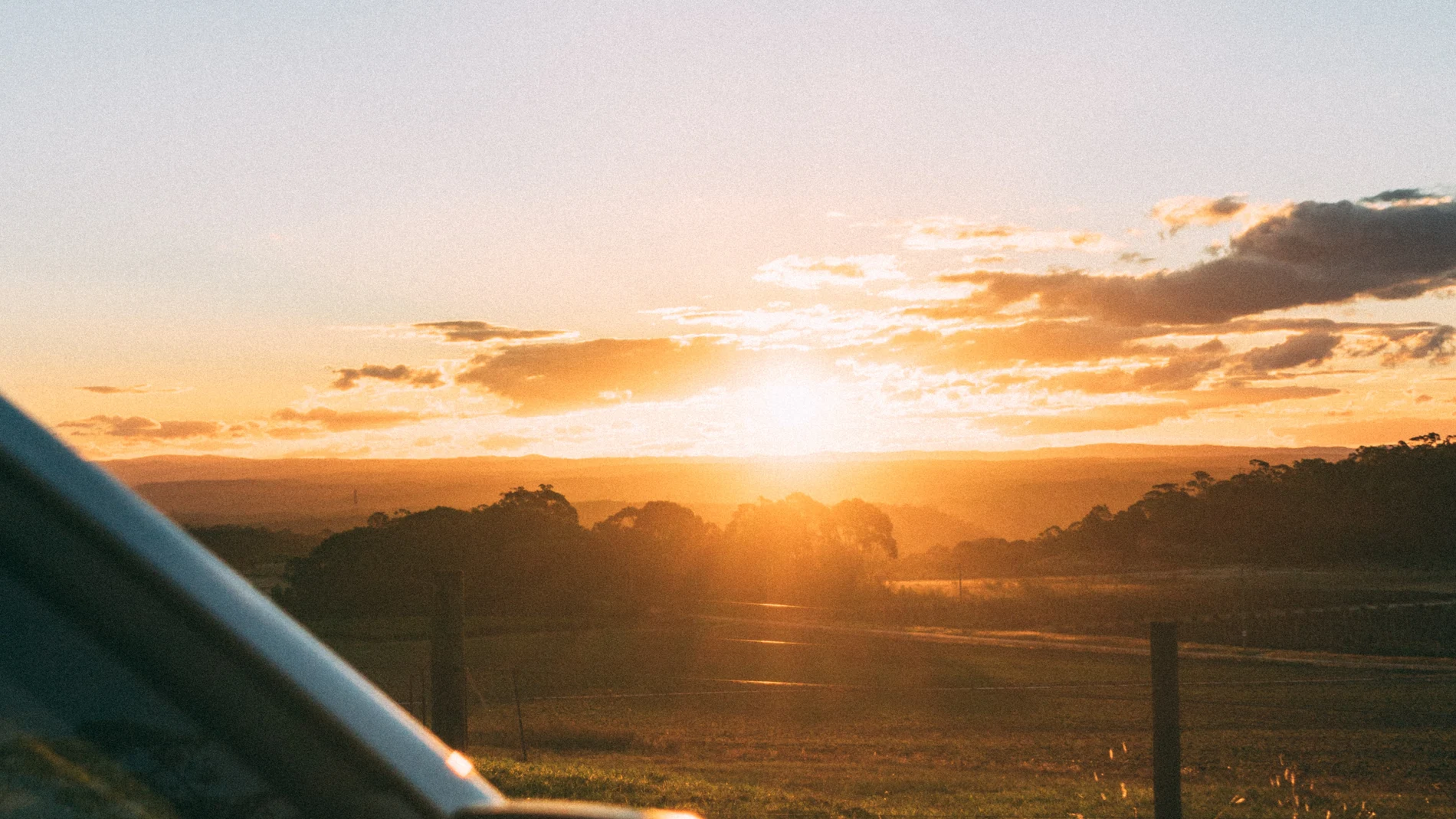 En la imagen, un coche aparcado frente al sol del atardecer.