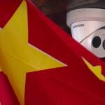 Una bandera china junto a una cámara de seguridad de la empresa Hikvision, afectada por la orden de Trump