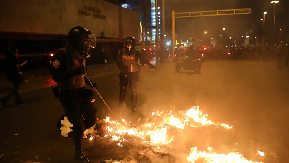 Agentes de policía tratan de apagar el fuego en Lima