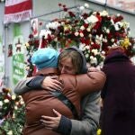 Dos mujeres se abrazan en un memorial por Raman Bandarenka en Minsk.