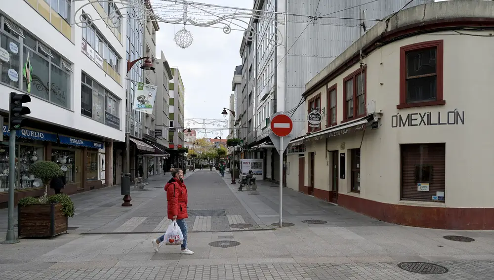 Una persona camina por una de las calles de Bergantiños (La Coruña) el día de la entrada en vigor de nuevas medidas y del cierre perimetral del municipio debido a la crisis del Covid-19