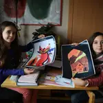 María, de 10 años y Verónica, de 8, posan con los dibujos, seleccionados para ilustrar el último libro de J. K. Rowling