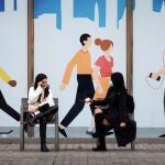 Dos mujeres conversan sentadas en un banco de las calles del barrio del Born de Barcelona