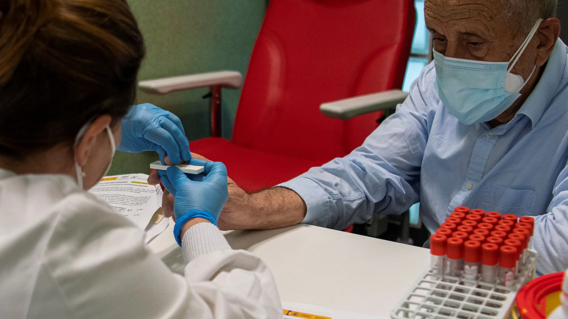 Un sanitario extrae una muestra de sangre a un paciente para un estudio de seroprevalencia
