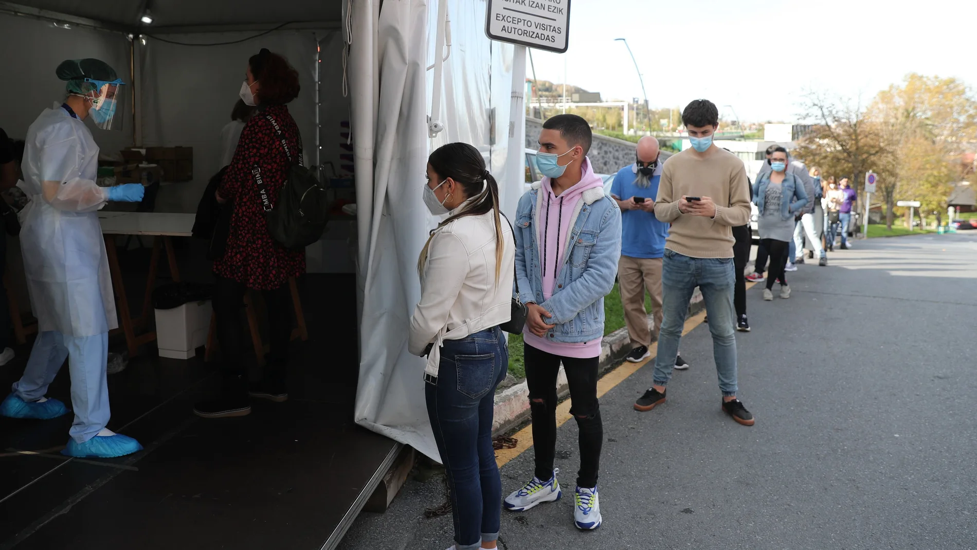 Vecinos de la localidad bilbaína de Santutxu esperan para someterse a una prueba de PCR en el hospital de la capital vizcaína