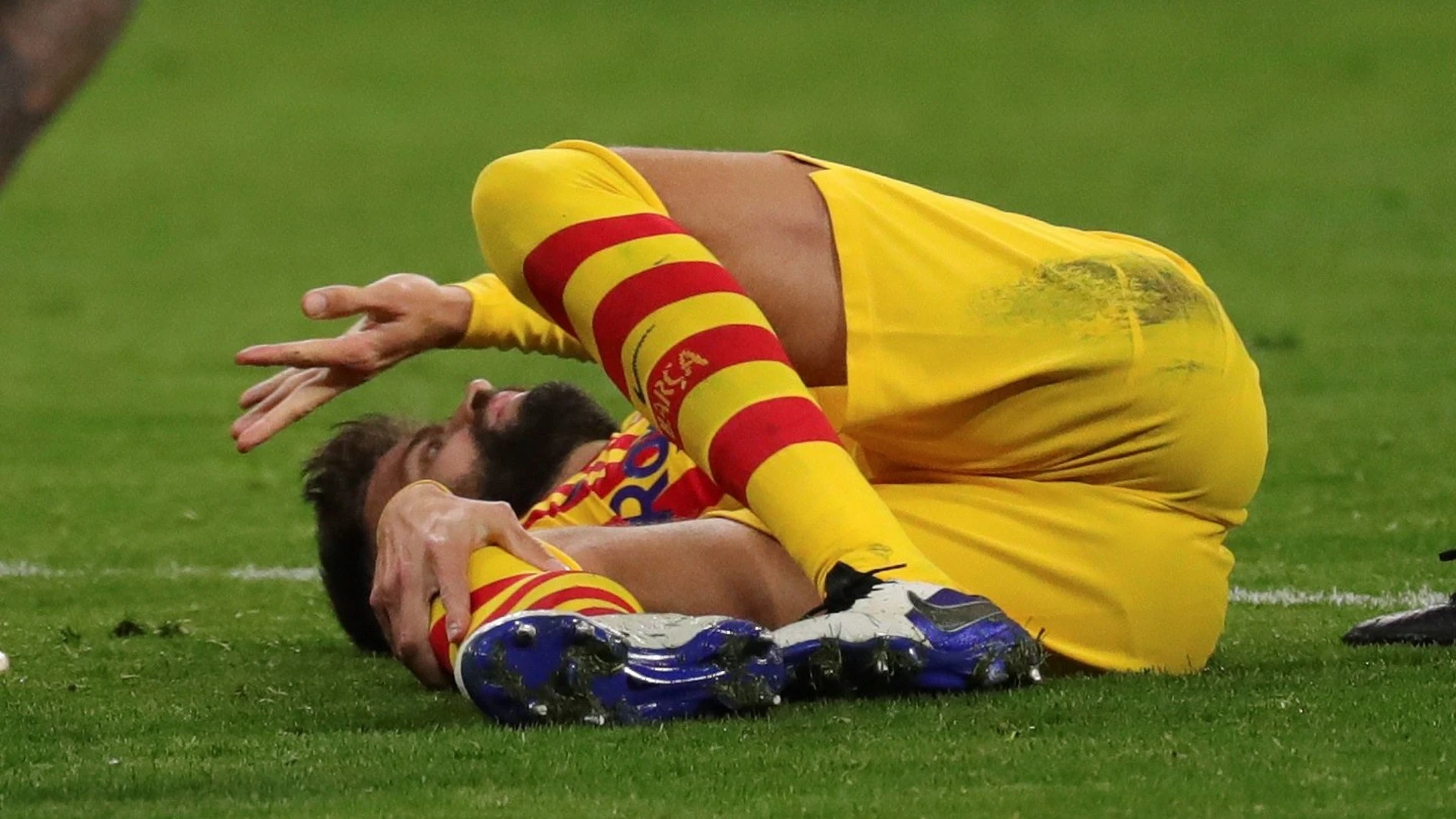 El defensa del FC Barcelona, Gerard Piqué, se duele en el suelo tras sufrir la lesión