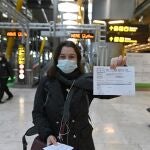 Una joven muestra el resultado de su PCR a su llegada al aeropuerto Adolfo Suárez-Barajas en Madrid, este lunes