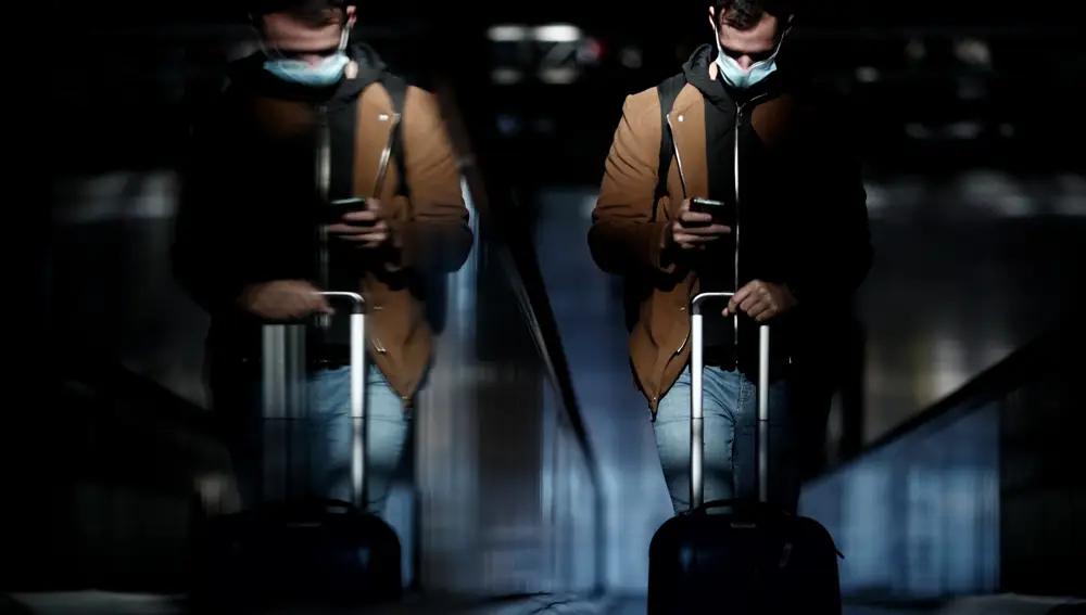 Un pasajero con maleta consulta el móvil en la terminal T4 del Aeropuerto de Madrid-Barajas Adolfo Suárez, en Madrid (España) | Fuente: Eduardo Parra / Europa Press