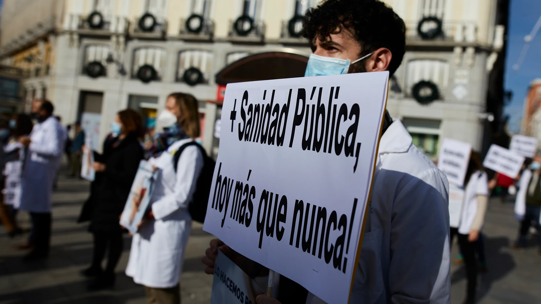Un trabajador sanitario sostiene una pancarta durante una concentración por la mejora de la sanidad pública