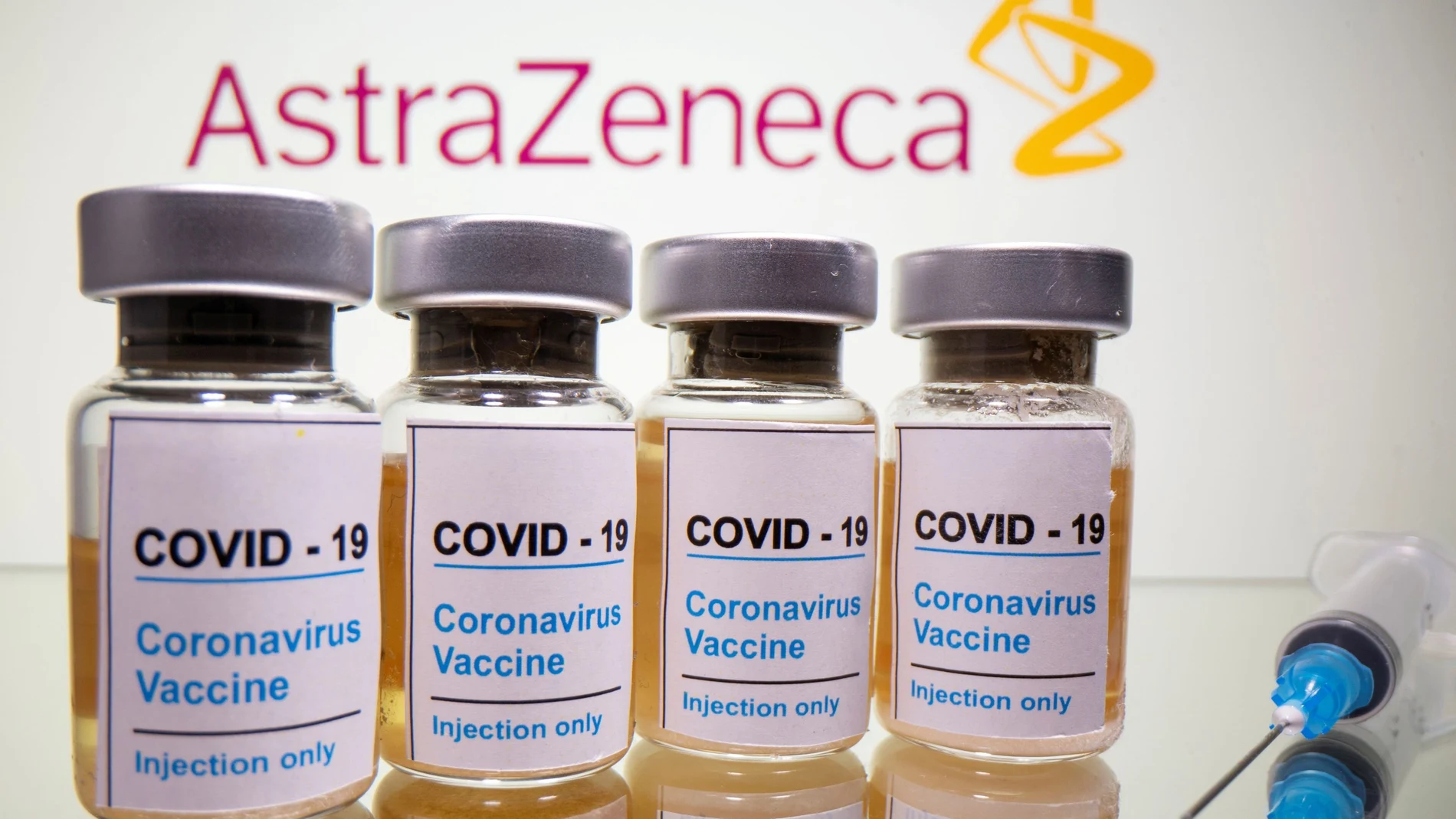 Vials with a sticker reading, "COVID-19 / Coronavirus vaccine / Injection only" and a medical syringe are seen in front of a displayed AstraZeneca logo in this illustration taken October 31, 2020. REUTERS/Dado Ruvic/Illustration