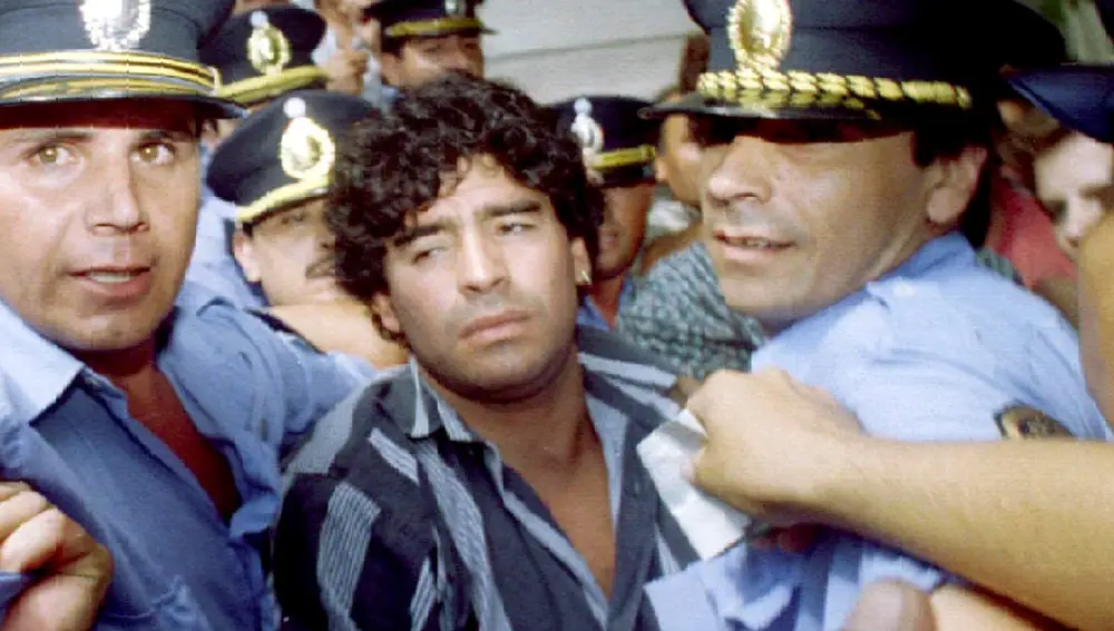 FILE PHOTO: A file photo shows Argentine soccer legend Diego Maradona (C) escorted by police as he leaves a courthouse after answering charges he shot and injured journalists outside his country home two months earlier, in the city of Mercedes 100 kilometers from Buenos Aires, March 15, 1994. REUTERS/File Photo