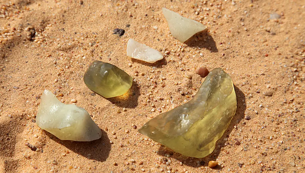 Varios fragmentos de cristal de Libia que presentan grados distintos de transparencia.