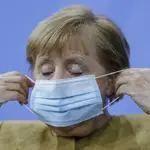 La canciller alemana, Angela Merkel, se coloca la mascarilla tras la rueda de prensa de esta noche en Berlín