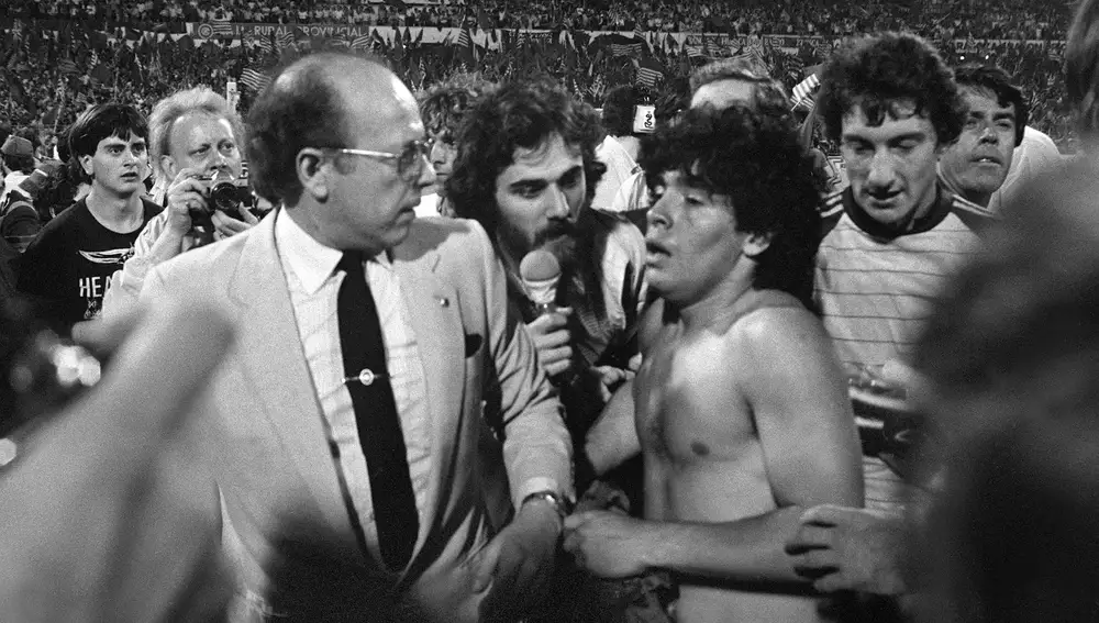 Zaragoza, 4-6-1983.- El Barcelona se ha proclamado campeón de la Copa del Rey, al derrotar esta noche en el estadio de La Romareda al Real Madrid por dos goles a uno. En la foto, un periodista intenta entrevistar en el terreno de juego al barcelonista Maradona. Detrás, el guardameta Urruti. Efe/cl