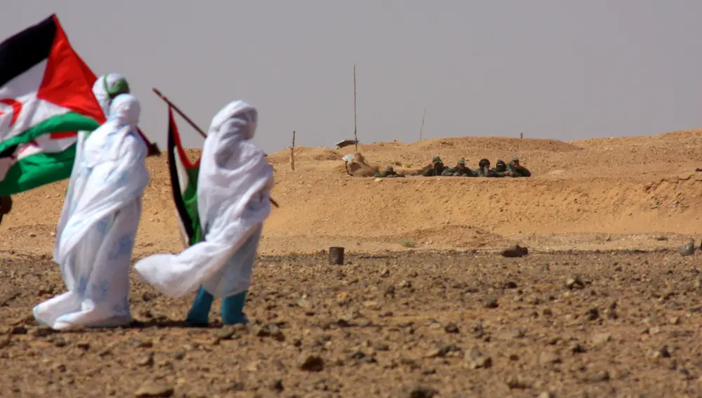 Saharauis ante soldados marroquíes en el muro