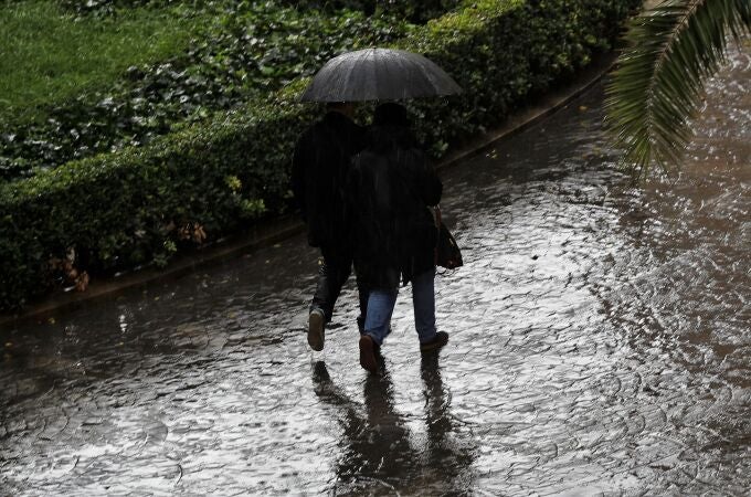 Dos personas se protegen bajo un paraguas de la intensa lluvia 
