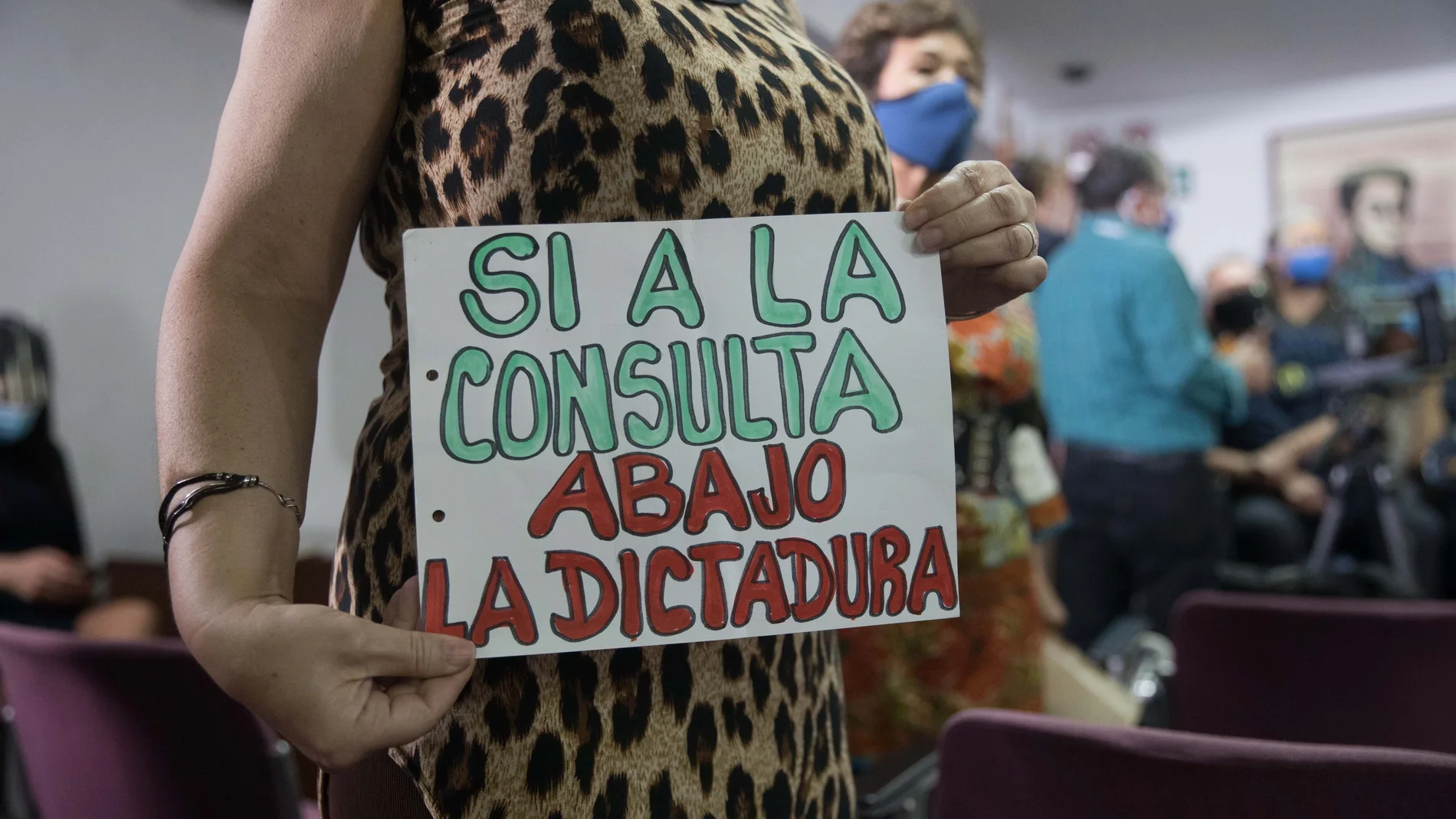 Una mujer sostiene un letrero en apoyo a la consulta popular auspiciada por el presidente de la Asamblea Nacional, Juan Guaidó