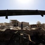 Un hombre camina entre los restos de una explosión en Yemen