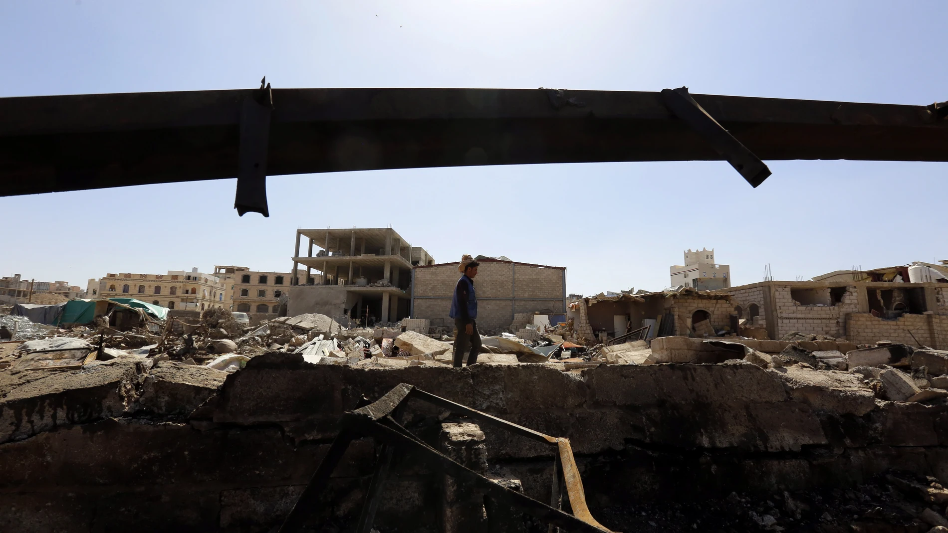 Un hombre camina entre los restos de una explosión en Yemen