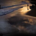 -FOTODELDIA- GRAFCAV1353. SAN SEBASTIÁN,- Varias personas se bañan al amanecer en la playa de Ondarreta de San Sebastián,