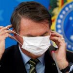 El presidente brasileño, Jair Bolsonaro, se ajusta una mascarilla