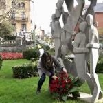 La alcaldesa de Guetxo, Amaia Agirrre deposita un ramo de flores al pie de la escultura ubicada en la plaza de San Ignacio