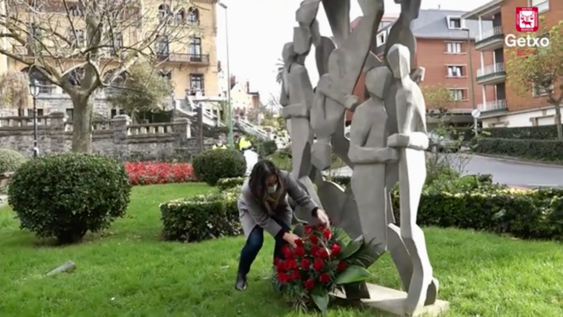 La alcaldesa de Guetxo, Amaia Agirrre deposita un ramo de flores al pie de la escultura ubicada en la plaza de San Ignacio