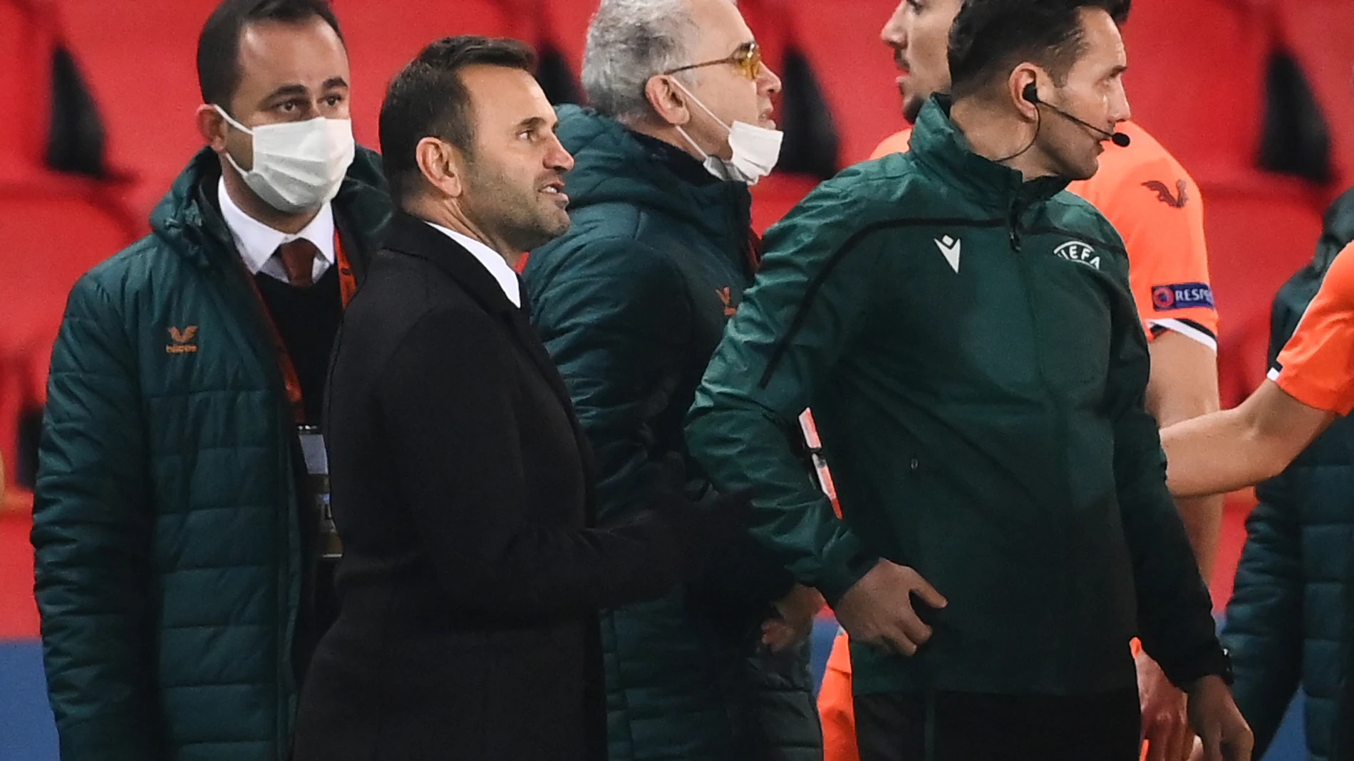 Okan Buruk, entrenador del Estambul Basaksehir, y el cuarto árbitro, Sebastian Coltescu, discuten en medio del jaleo