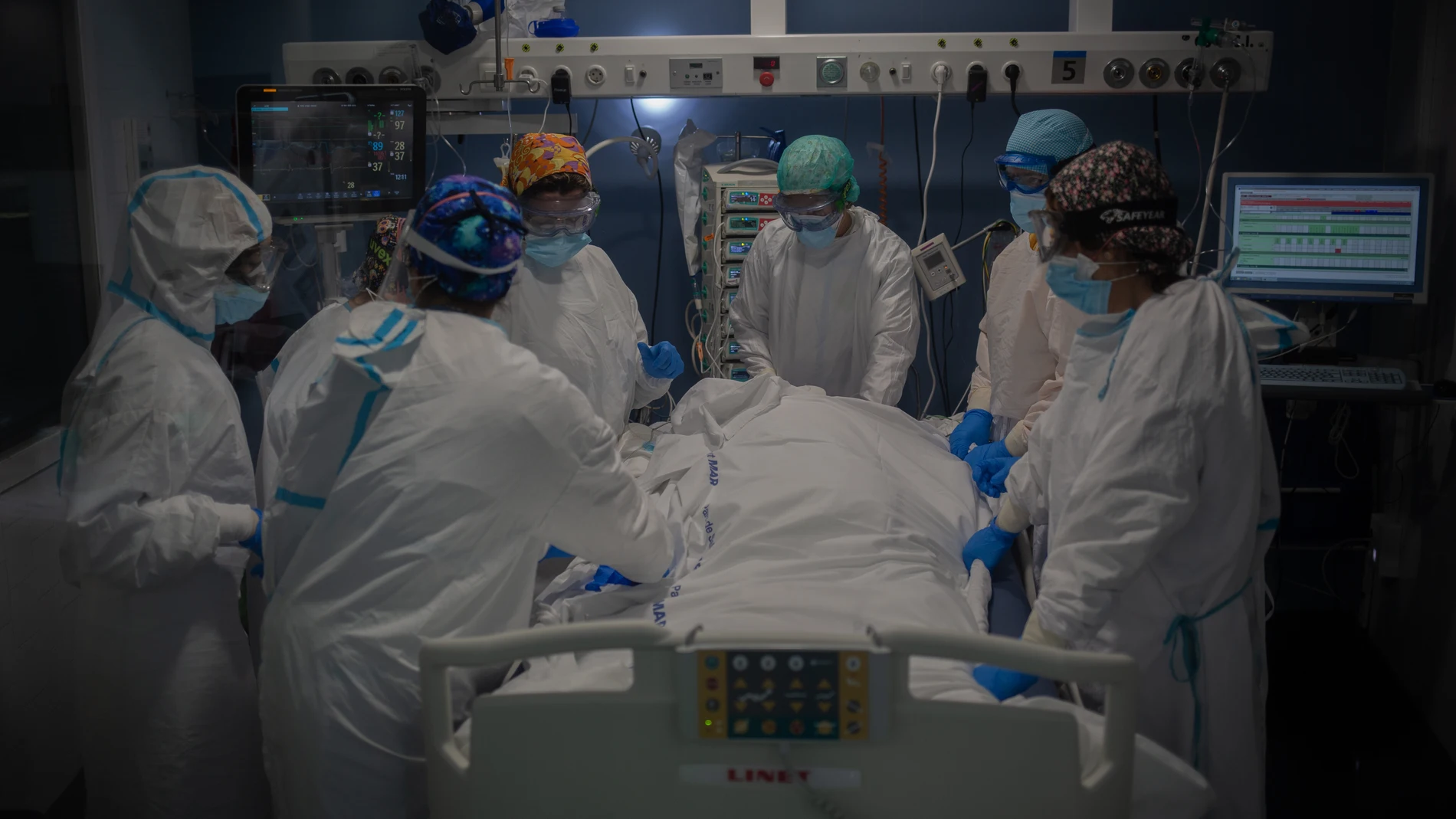 Trabajadores sanitarios protegidos atienden a un paciente en la Unidad de Cuidados Intensivos –UCI- del Hospital del Mar, en Barcelona, Catalunya (España), el pasado 19 de noviembre