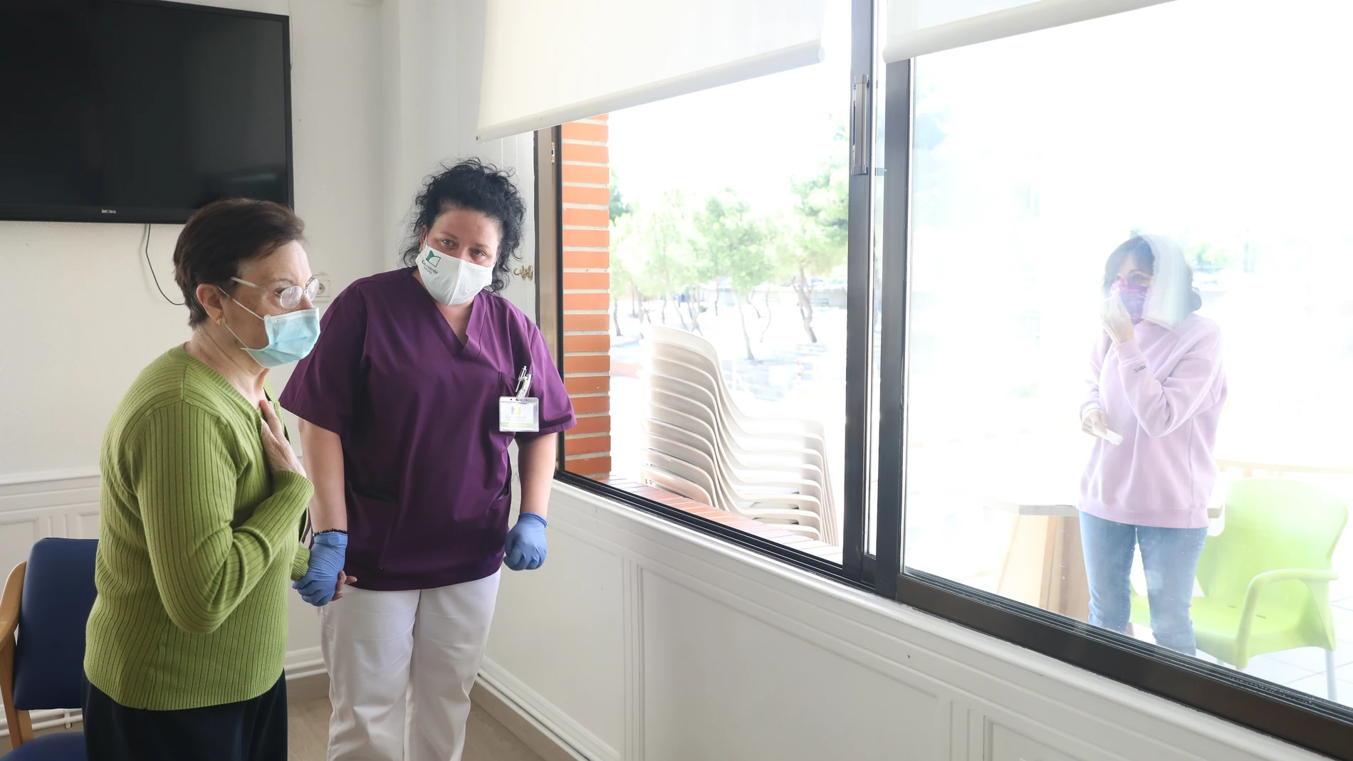 Una residente se comunica con una familiar por una ventana de la Residencia Centro Casaverde Navalcarnero