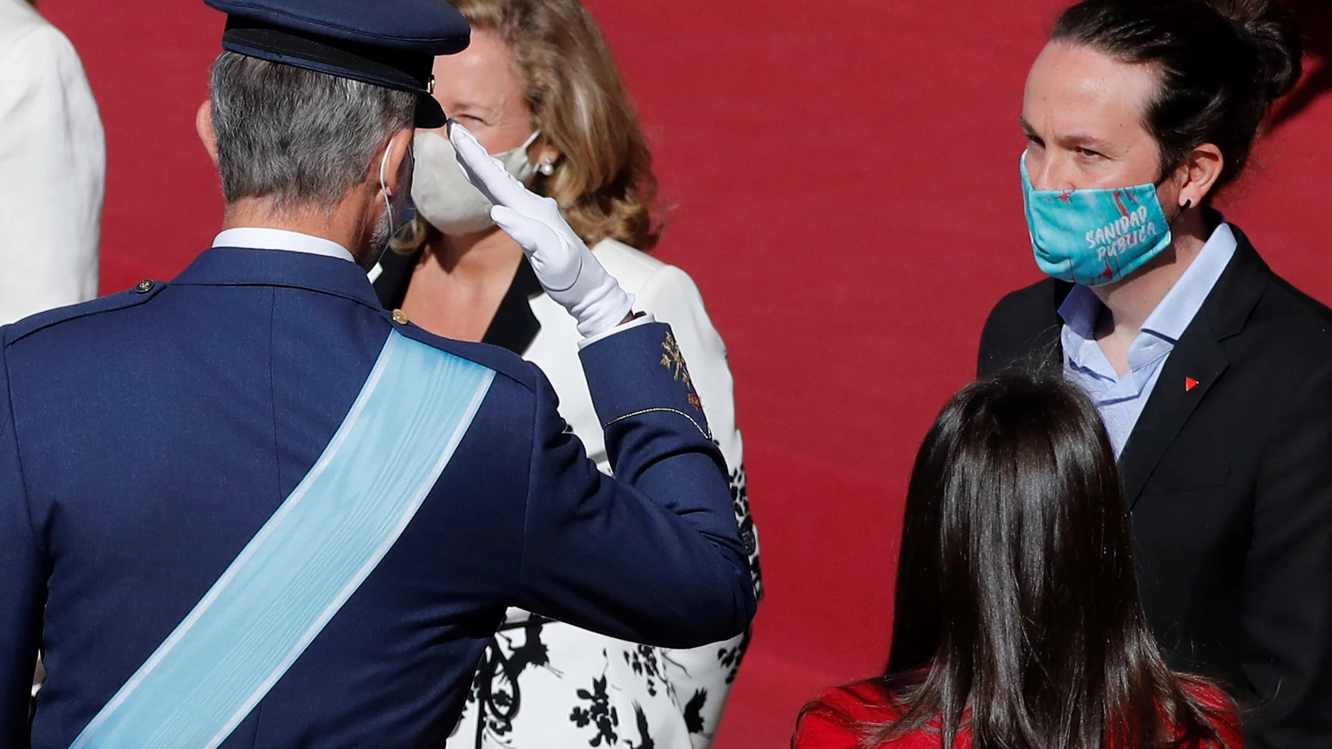 El Rey Felipe VI saluda al vicepresidente segundo, Pablo Iglesias, durante el acto del 12-O