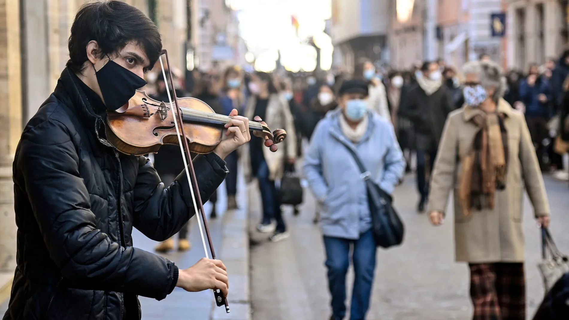 Un músico callejero toca en una vía de Roma