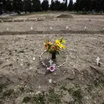 Flores y piedras con forma de corazón en un cementerio en Campo 81, una zona para enterrar a víctimas de la covid-19 en Milán