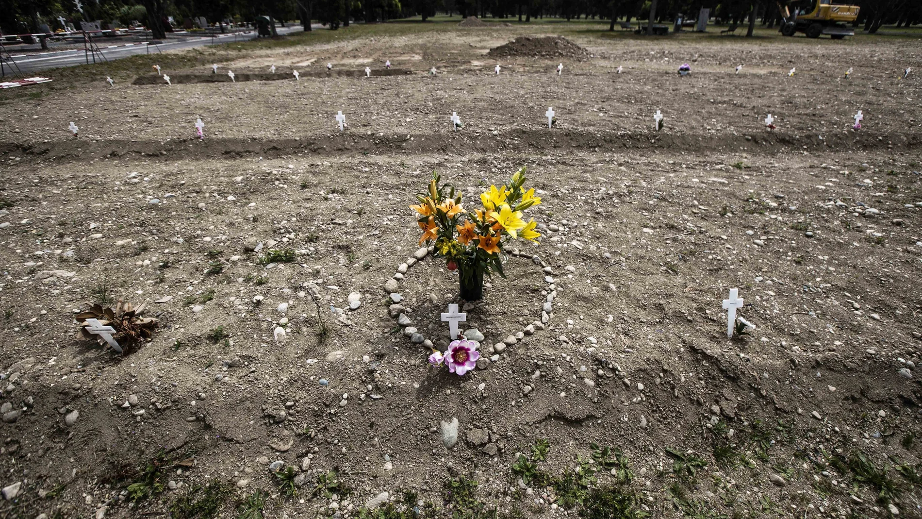Flores y piedras con forma de corazón en un cementerio en Campo 81, una zona para enterrar a víctimas de la covid-19 en Milán