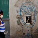 Una mujer camina frente a una pared con cables eléctricos expuestos en La Habana (Cuba)