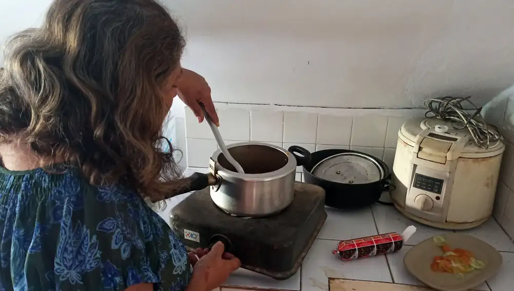 Una mujer prepara alimentos en una cocina eléctrica en La Habana