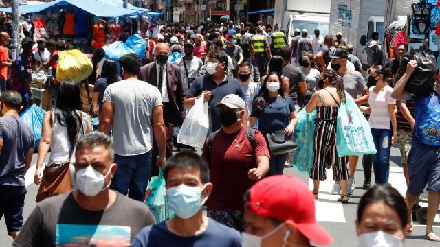 AME5799. SAO PAULO (BRASIL), 18/12/2020.- Decenas de personas caminan en una concurrida vía comercial hoy, en el centro de Sao Paulo (Brasil). El Gobierno brasileño exigirá a partir del 30 de diciembre próximo que los ciudadanos nacionales y extranjeros que desembarquen en cualquier aeropuerto del país procedentes del exterior presenten un examen demostrando que no están contagiados de covid-19. Brasil registró el jueves 1.092 muertes por covid, con lo que volvió a superar el millar de fallecimientos diarios por primera vez desde el 30 de septiembre (1.031) y acumula 184.827 víctimas de la pandemia. EFE/ Sebastiao Moreira