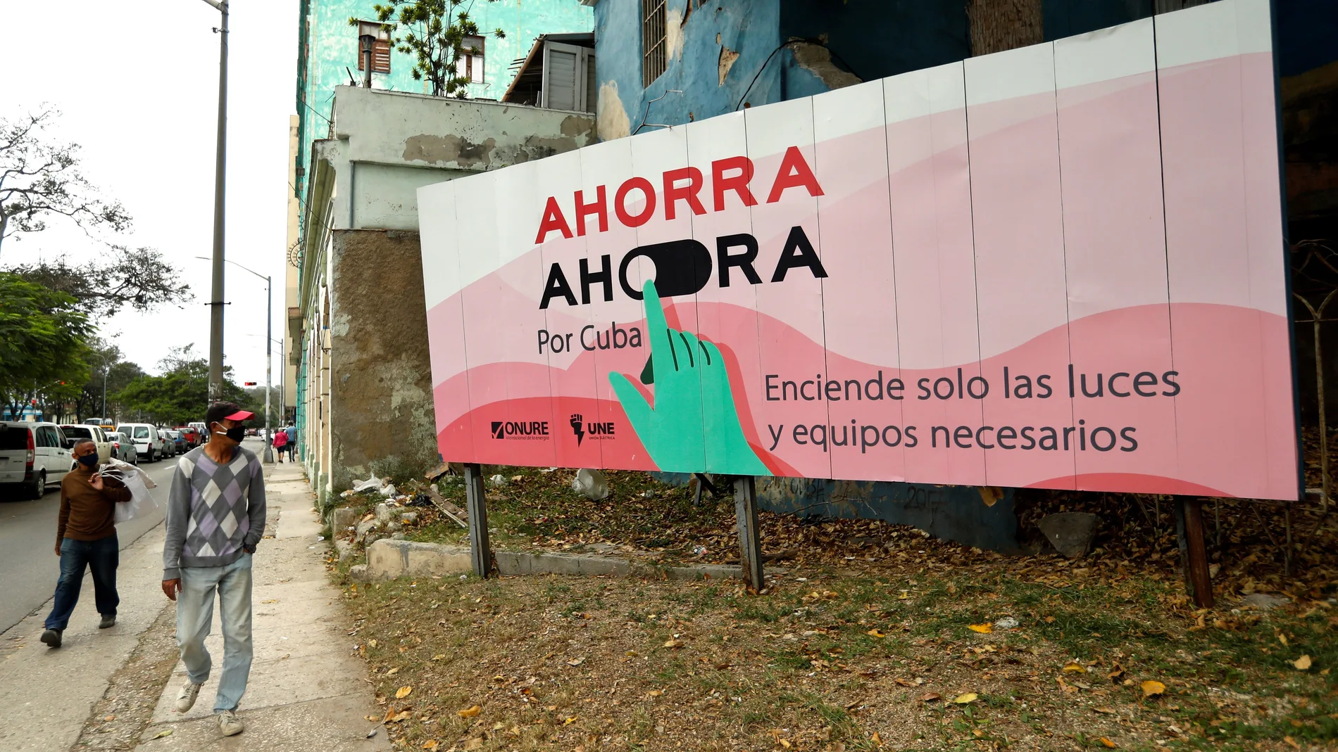 Un hombre camina frente a una valla que exhorta al ahorro de electricidad en La Habana (Cuba)